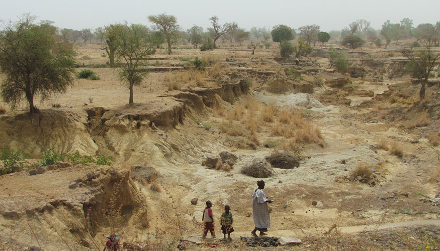 People standing in a dry riverbed in Burkina Faso, Africa.