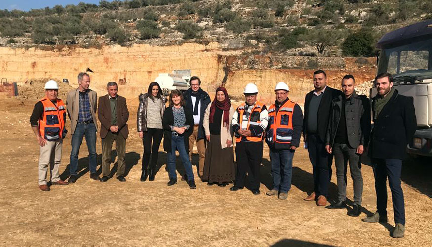 Outdoors group picture of Dutch Water Authorities team members and Palestinian partners during a visit at a building site.