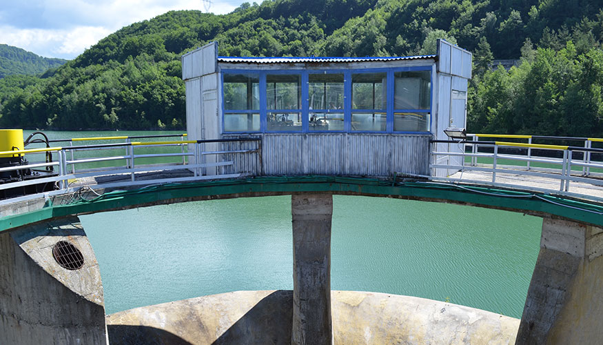 Large dam and man-made lake surrounded by hills in Romania.