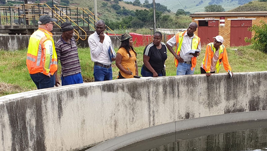 People standing next to a waste water reservoir during a Dutch Water Authorities field visit in South Africa.