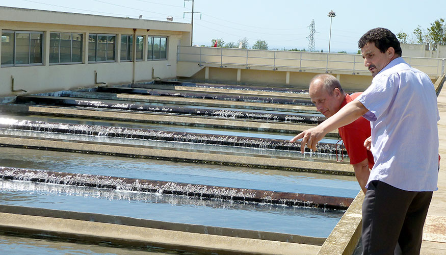 Two men inspecting a waste water treatment plant.