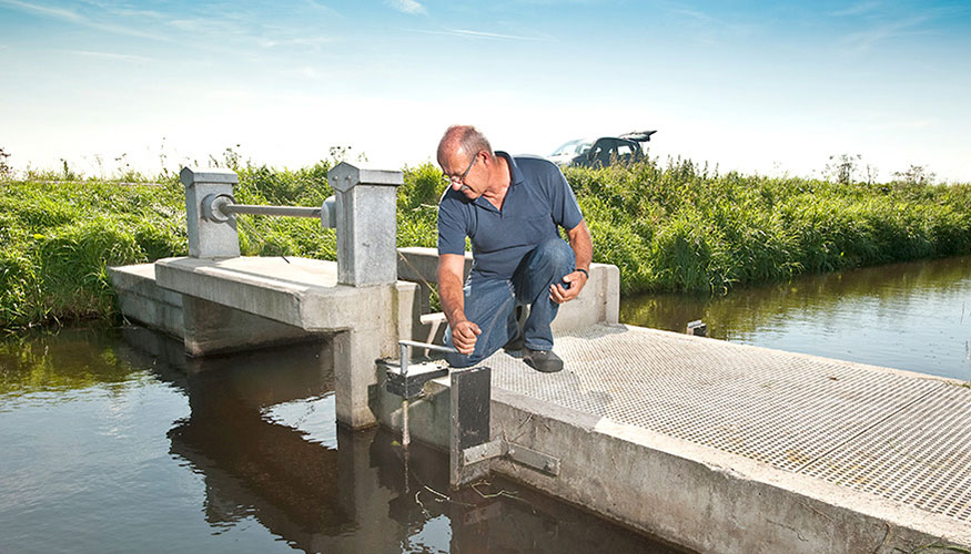 Regional water authority employee performing maintenance at a weir in the Netherlands.