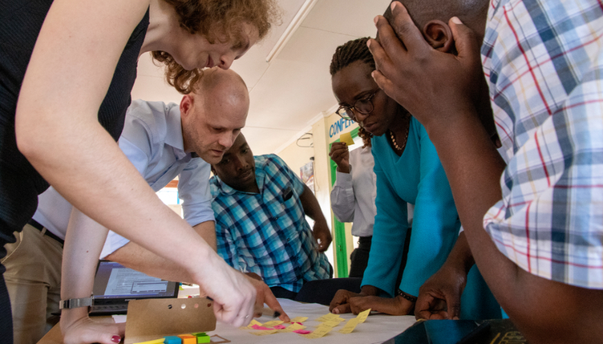 A group of people is looking at sticky notes on a table