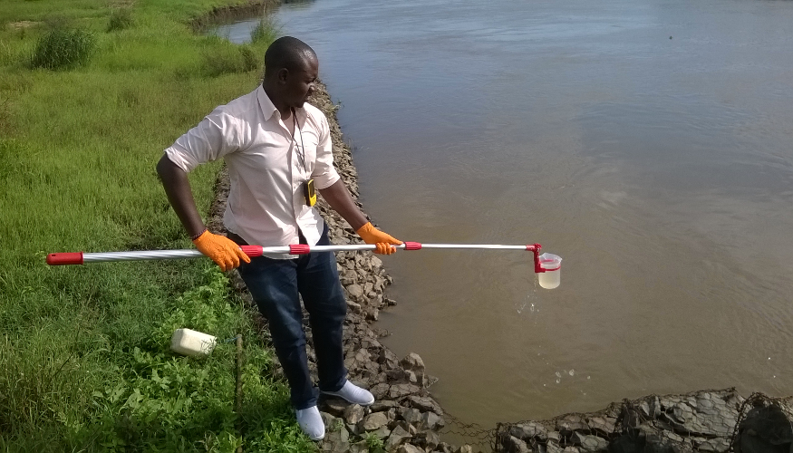A man is taking a sample from the water