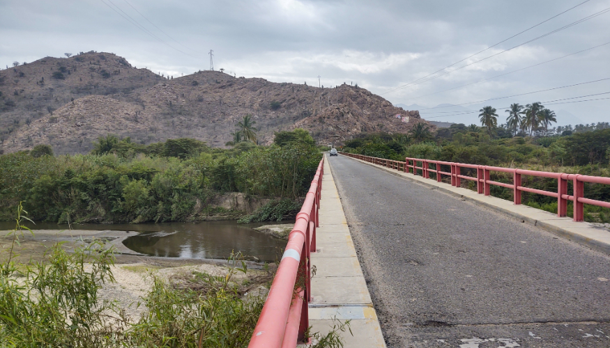 Photo of a road on a bridge, with mountains in the background