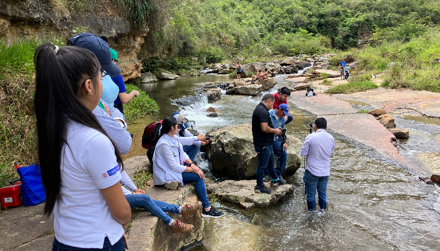 A group of people is standing knee deep in the water to monitor the water.