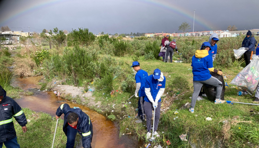 A group of people is cleaning up the area near a small river