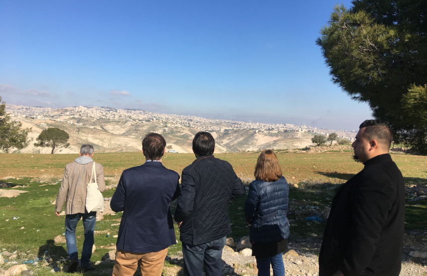 5 people overlook the West Bank from a distance