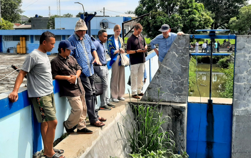 A group of people is inspecting a small sluice