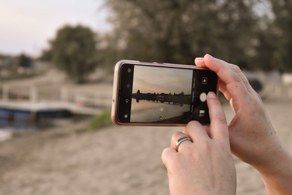 Mobiele camera vastgehouden door 2 handen filmt landschap.